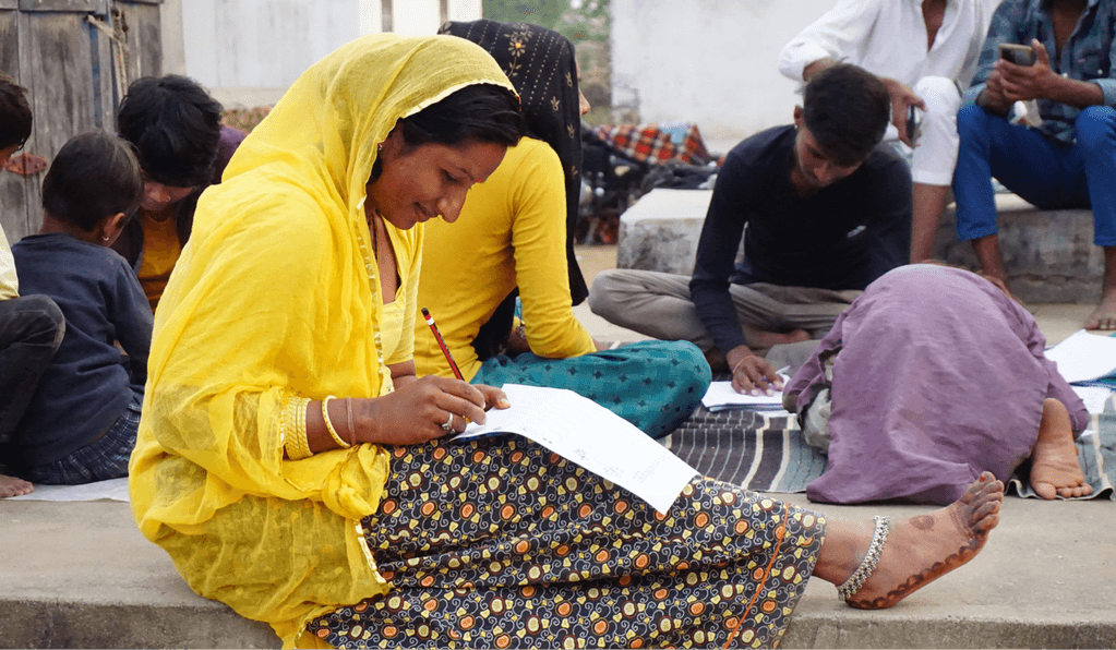 Women and children learning at a night school in Bhervai, Rajasthan
